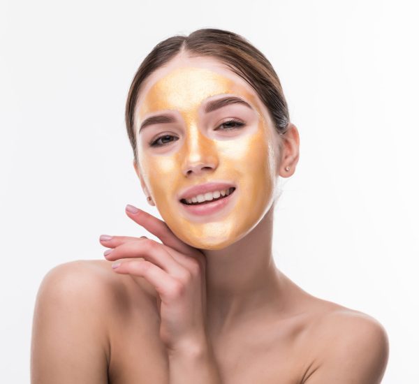 Woman with gold mask. Beautiful woman with Golden mask on face skin cosmetic touch Face. Beauty Skincare and Treatment
